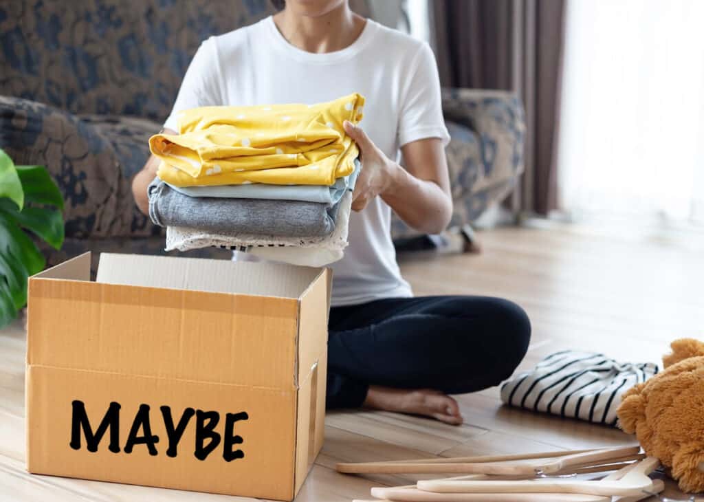 Woman holding Clothes with Donate Box In her room, Donation Concept.