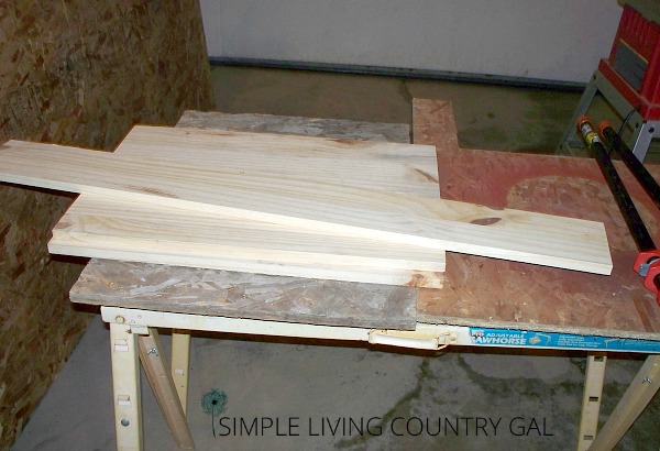 Wood pieces lying in a pile on saw horses. 