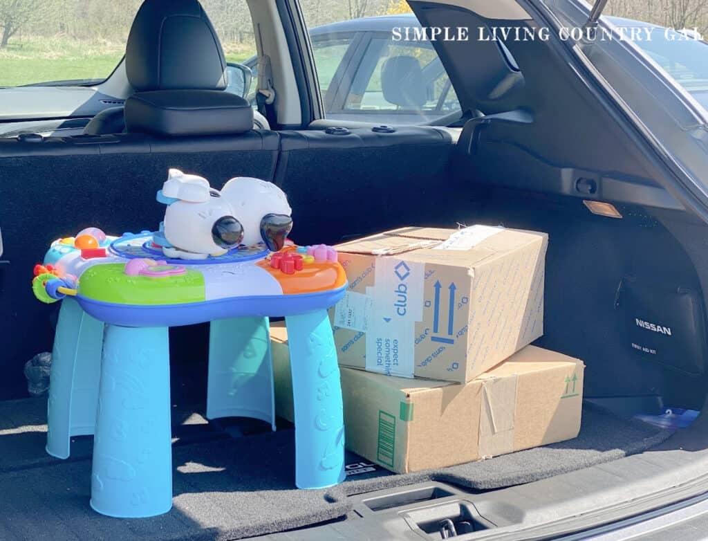 boxes and toys in a trunk of a car ready for donation 