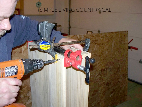 A man screwing boards together near to a vice clamp