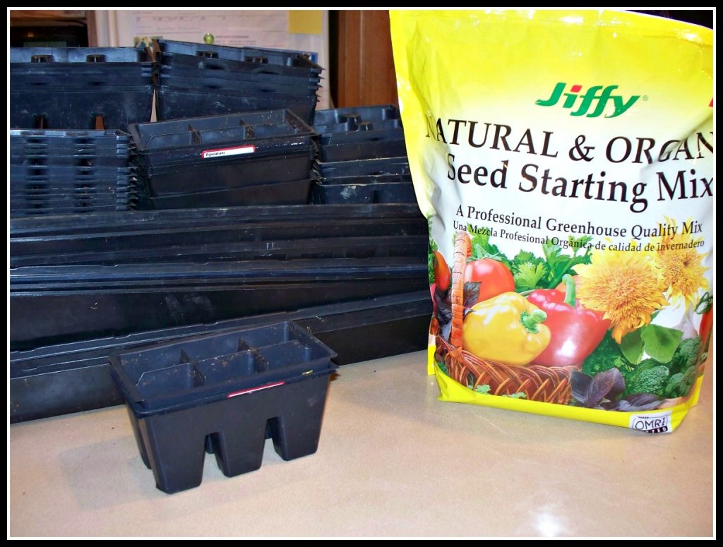 a stack of seed flats and soil on a counter