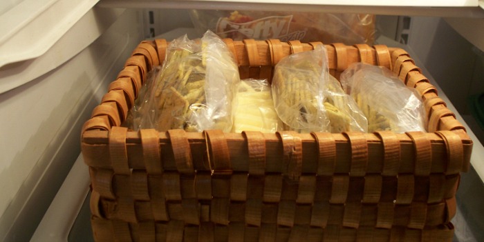The lunch basket is ready for the week and put on the highest shelf in the refridgerator. 