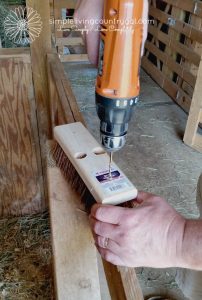 Hands drilling holes in the back of a brush head 