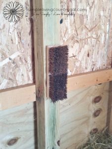 A brush head attached to a barn wall 