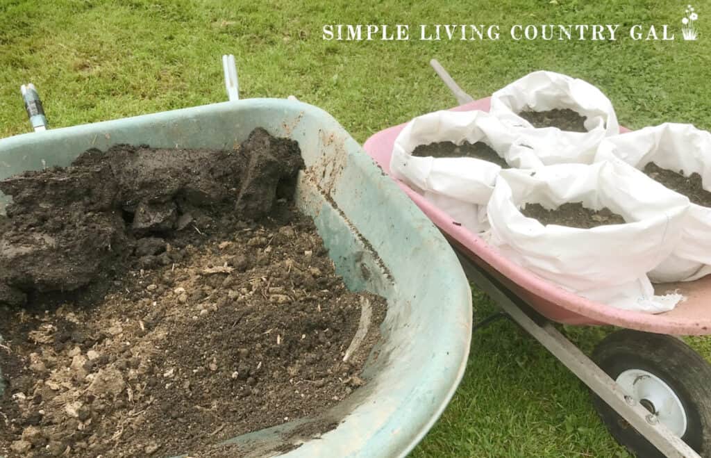 a wheelbarrow of soil next to bags of soil copy