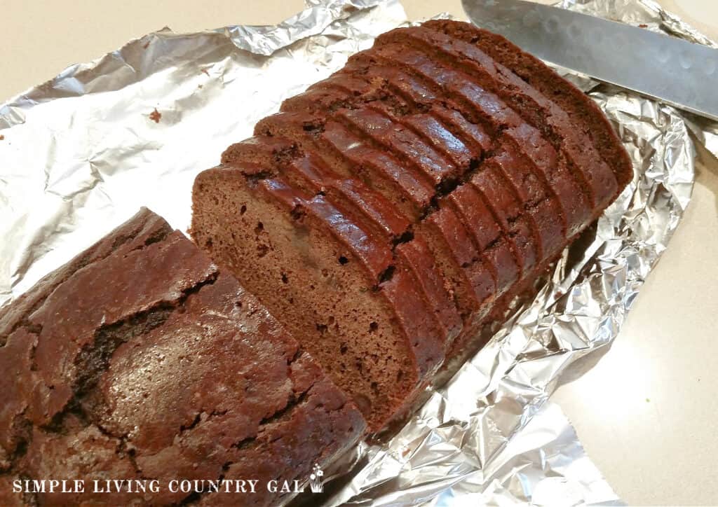 zucchini bread sliced on a sheet of tin foil sitting on a counter