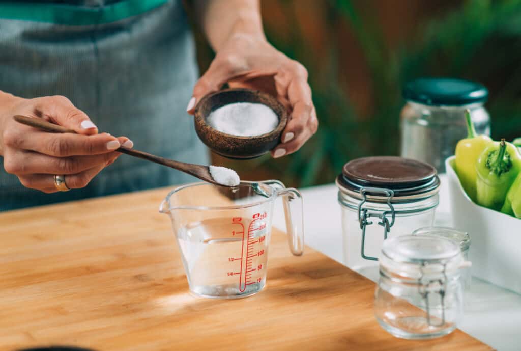 A woman measuring ingredients into a cup