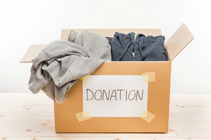 a cardboard box with a big label that says donation filled with clothes