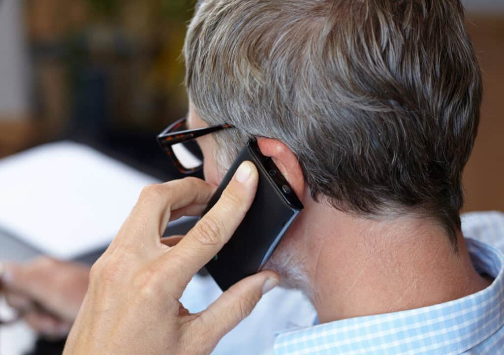 man from behind talking on a cell phone