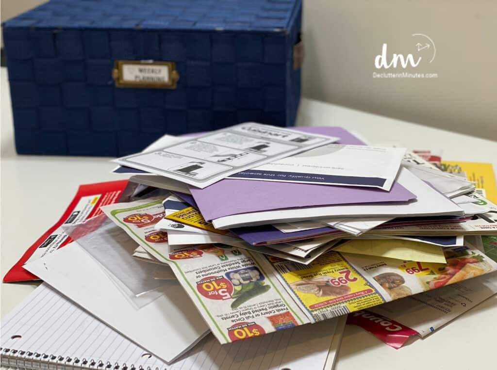 a basket sitting in front of a stack of paper clutter copy