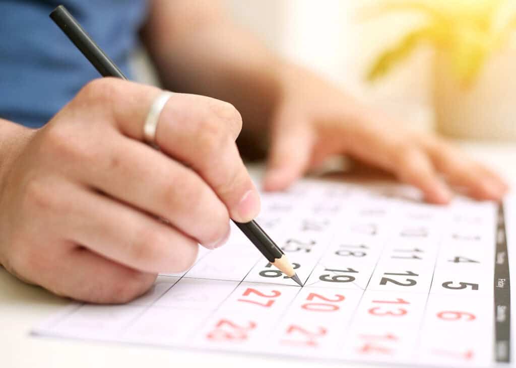 woman writing finance dates on a calendar