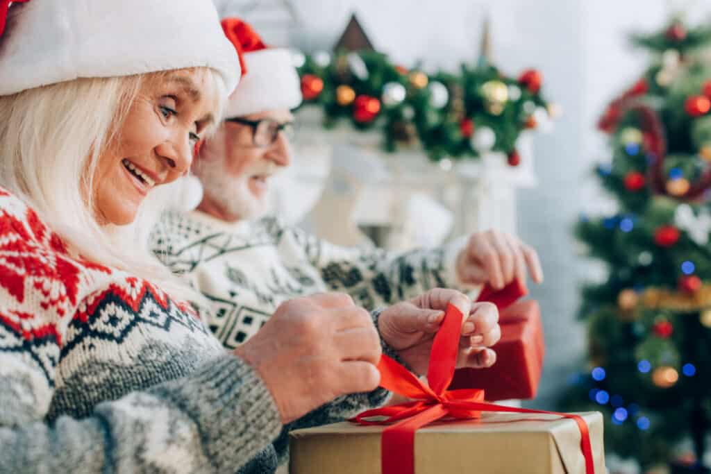 an older couple opening gifts at christmas