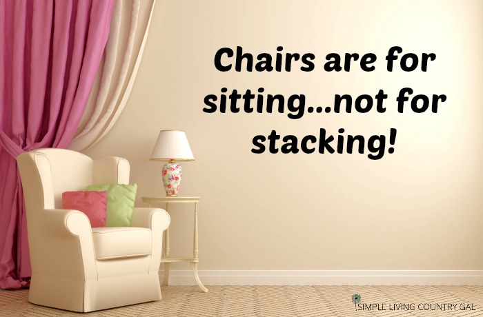 The words "Chairs are for sitting...not stacking!" on the wall next to a light pink chair