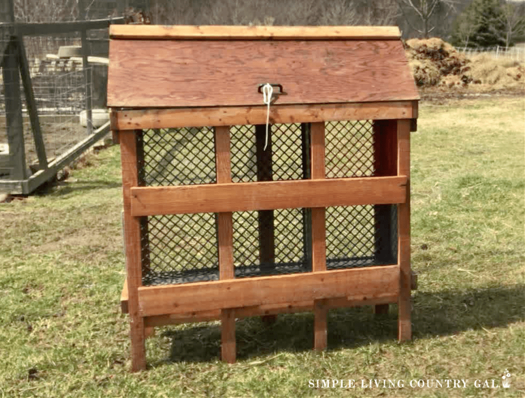 a diy chicken nesting box setup in a backyard near a coop