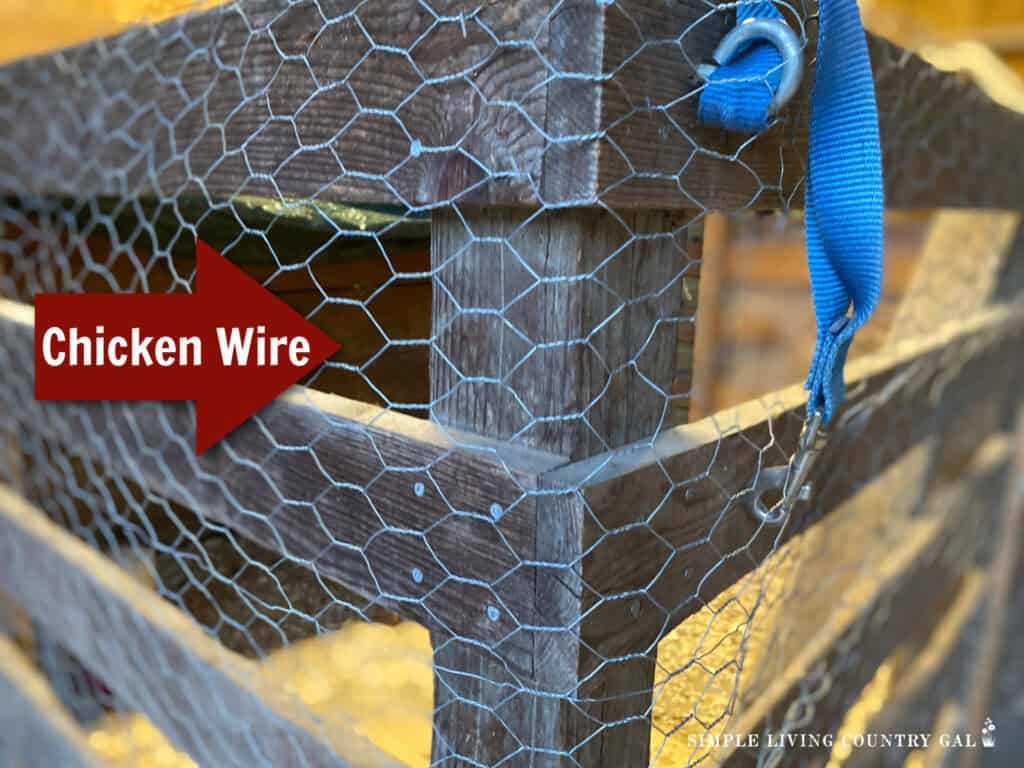an arrow pointing to chicken wire in the outside of a pen in a barn