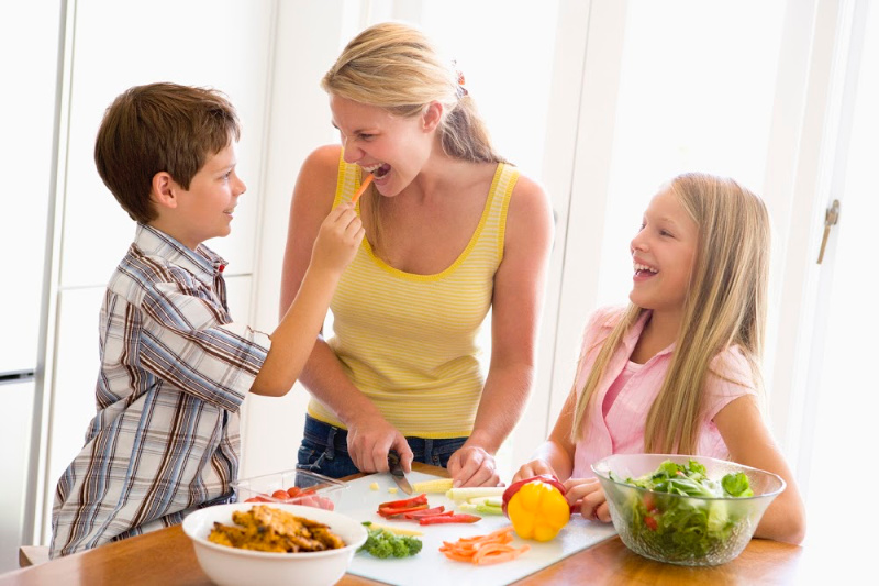 a young mother with 2 kids making dinner