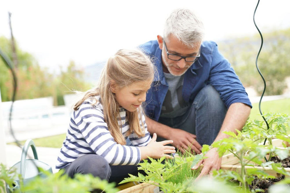 A father and daughter learn about plants in a family garden