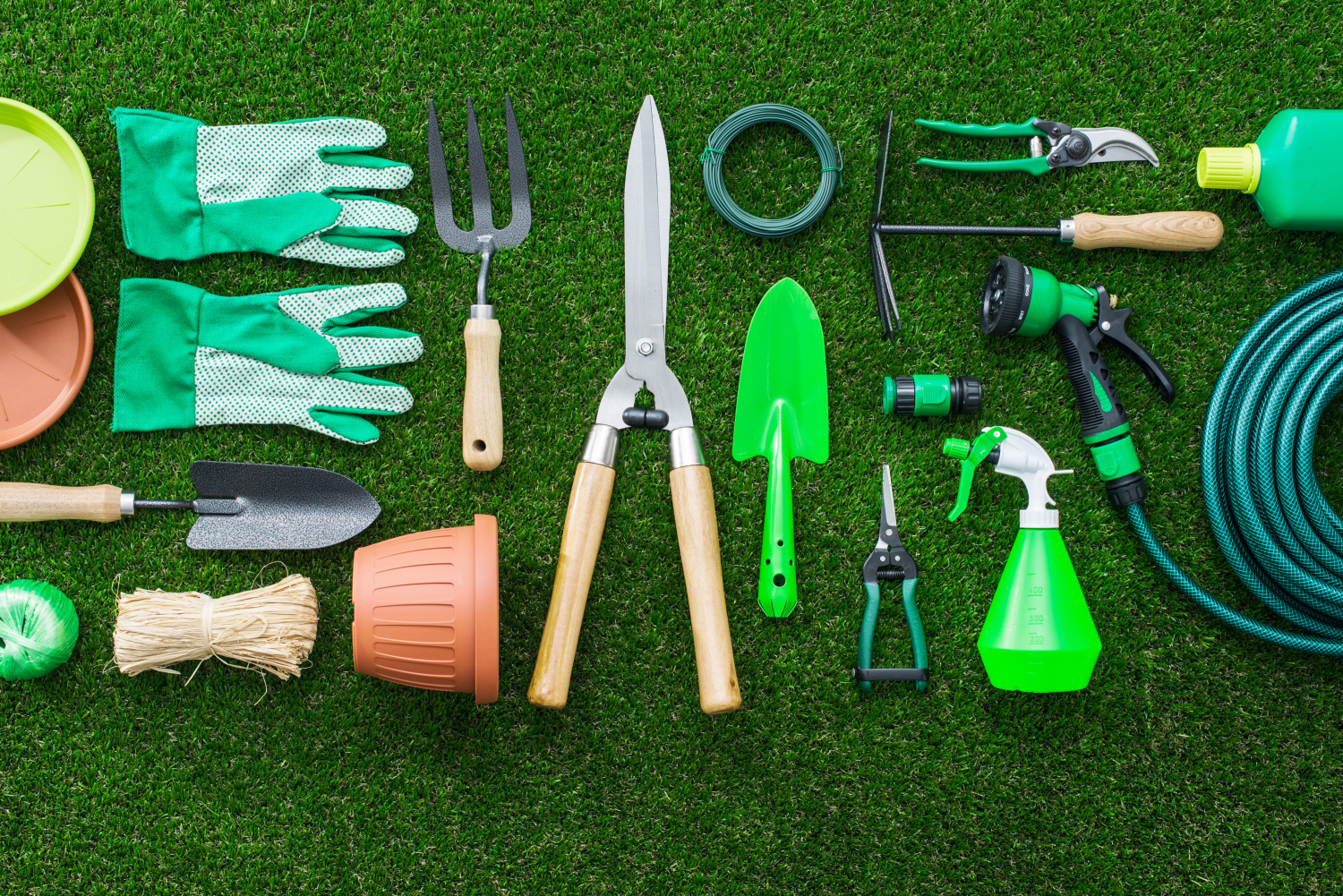 a collection of gardening tools spread out on the grass. 