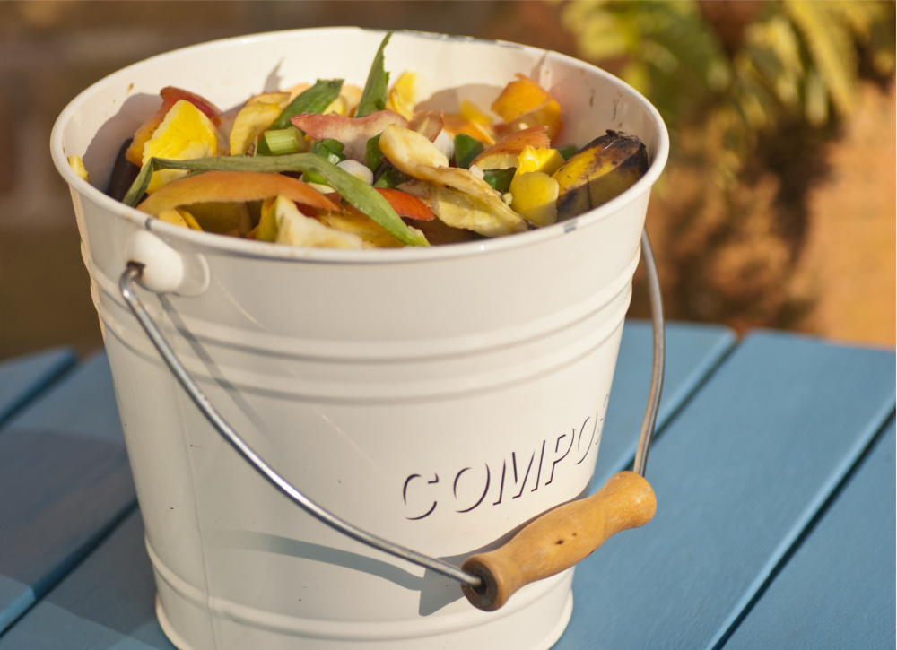 An indoor composting bucket full of vegetable scraps.