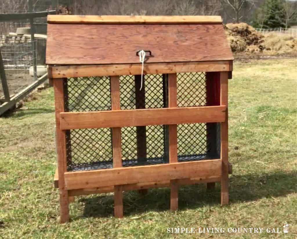 A wooden nesting box frame with 6 milk crates inside 
