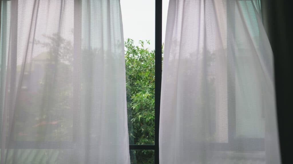 window that is opened with curtains blowing