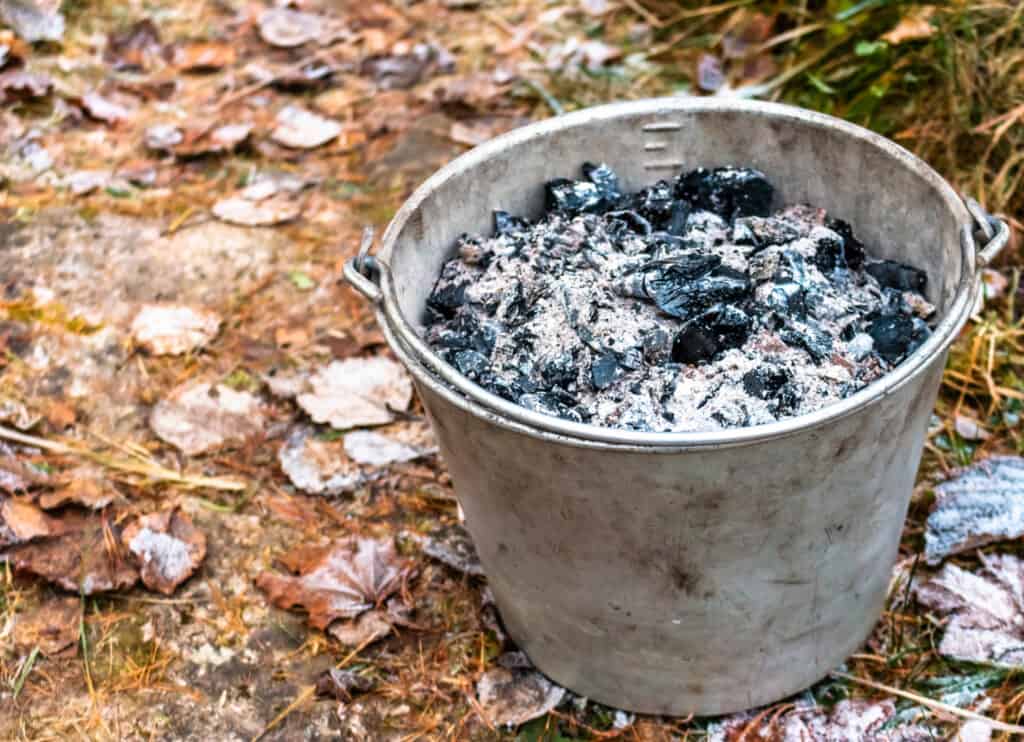 a bucket of wood ash sitting in a yard