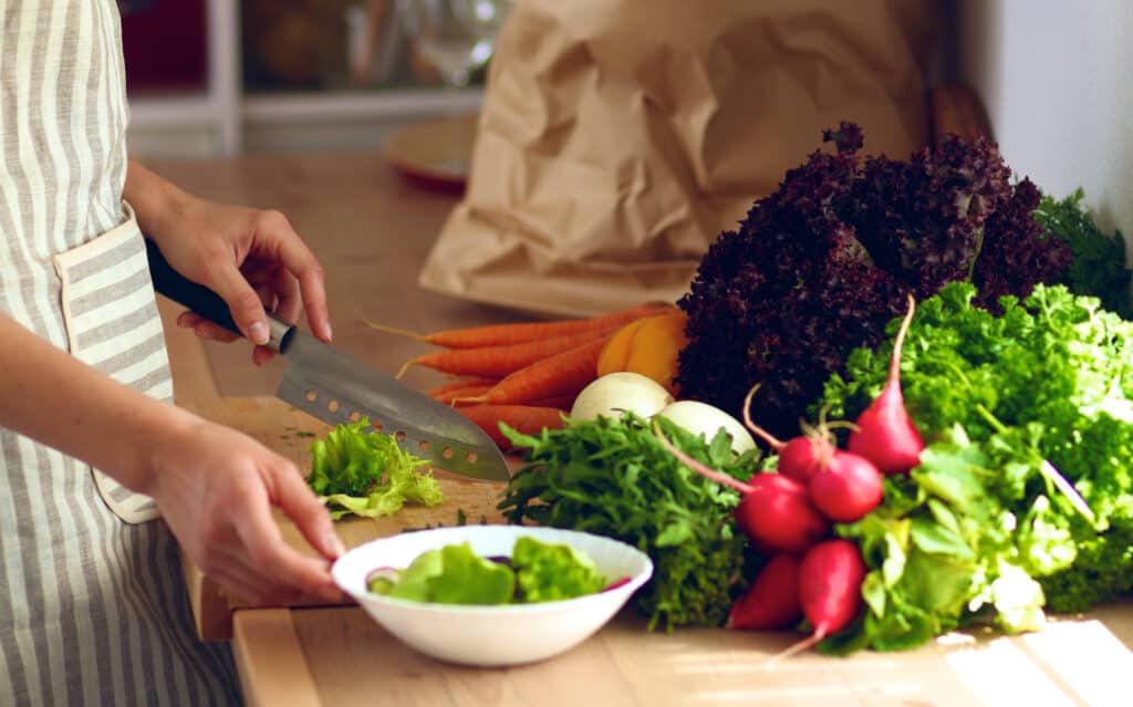 Young woman cutting vegetables in the kitchen