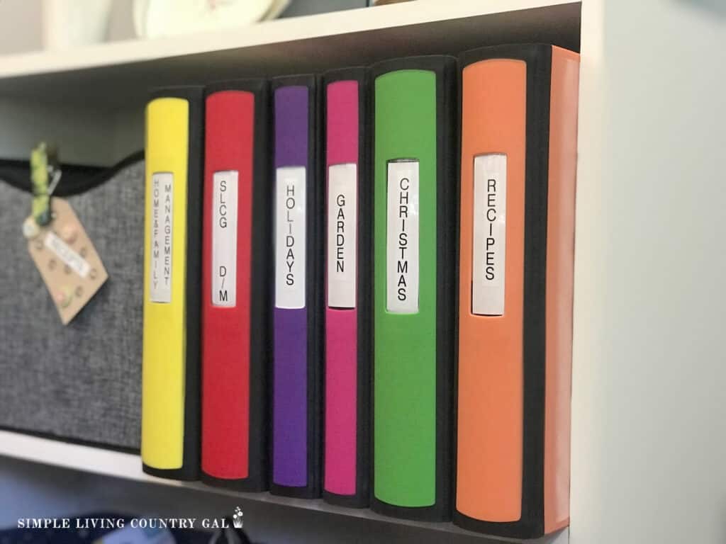 a collection of colorful binders on a shelf