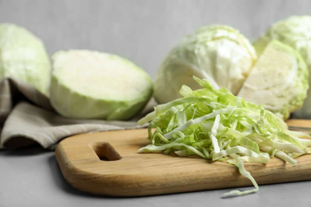 Fresh shredded cabbage on grey table, closeup