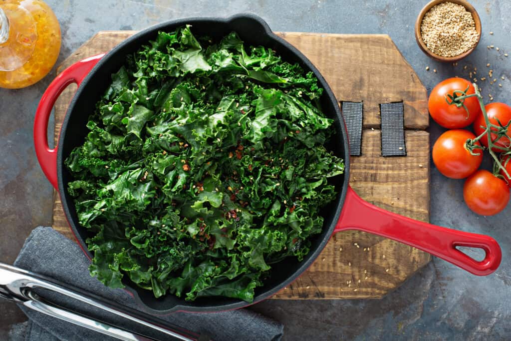 a pan of fresh kale with pepper flakes sprinkled throughout