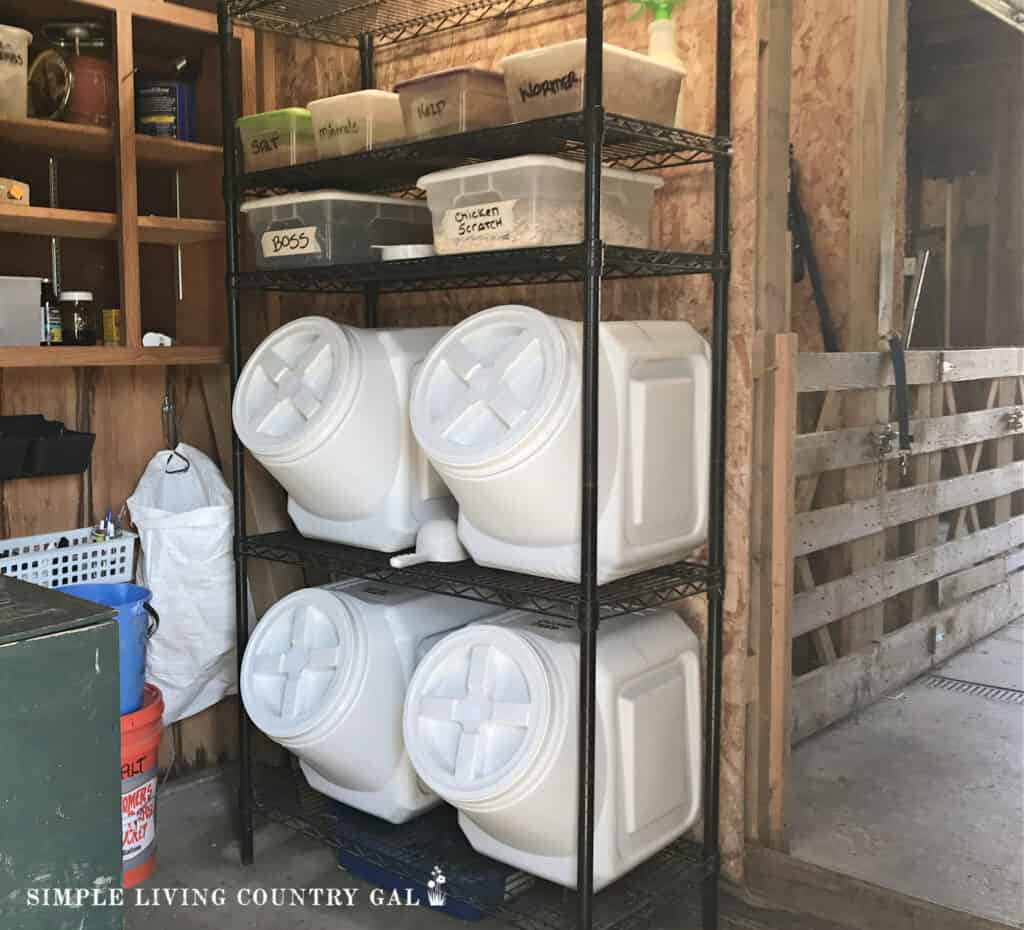 white storage containers on a black wire shelf in a feed room