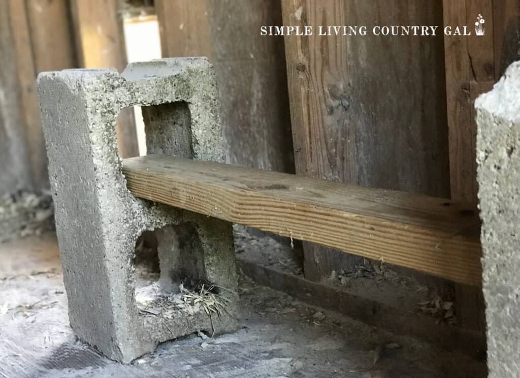 2 cinder blocks with a 2x4 fed through the openings in a chicken coop