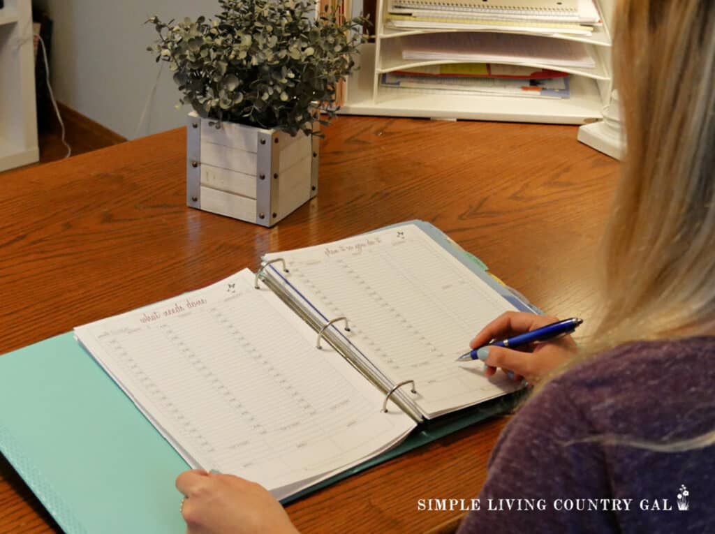 a girl writing gardening notes in a planner at a desk