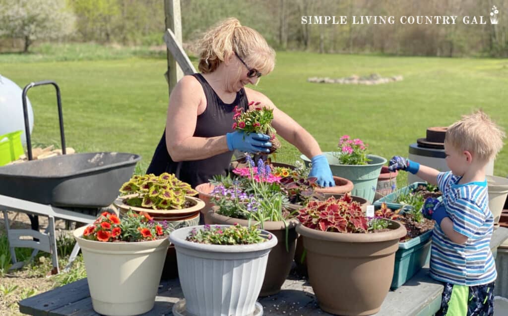 young boy planting containers with a woman