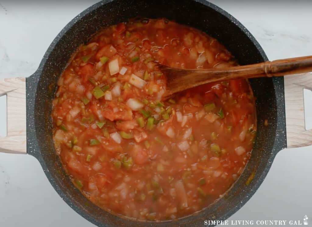 a pot of tomato garden salsa with a wood spoon