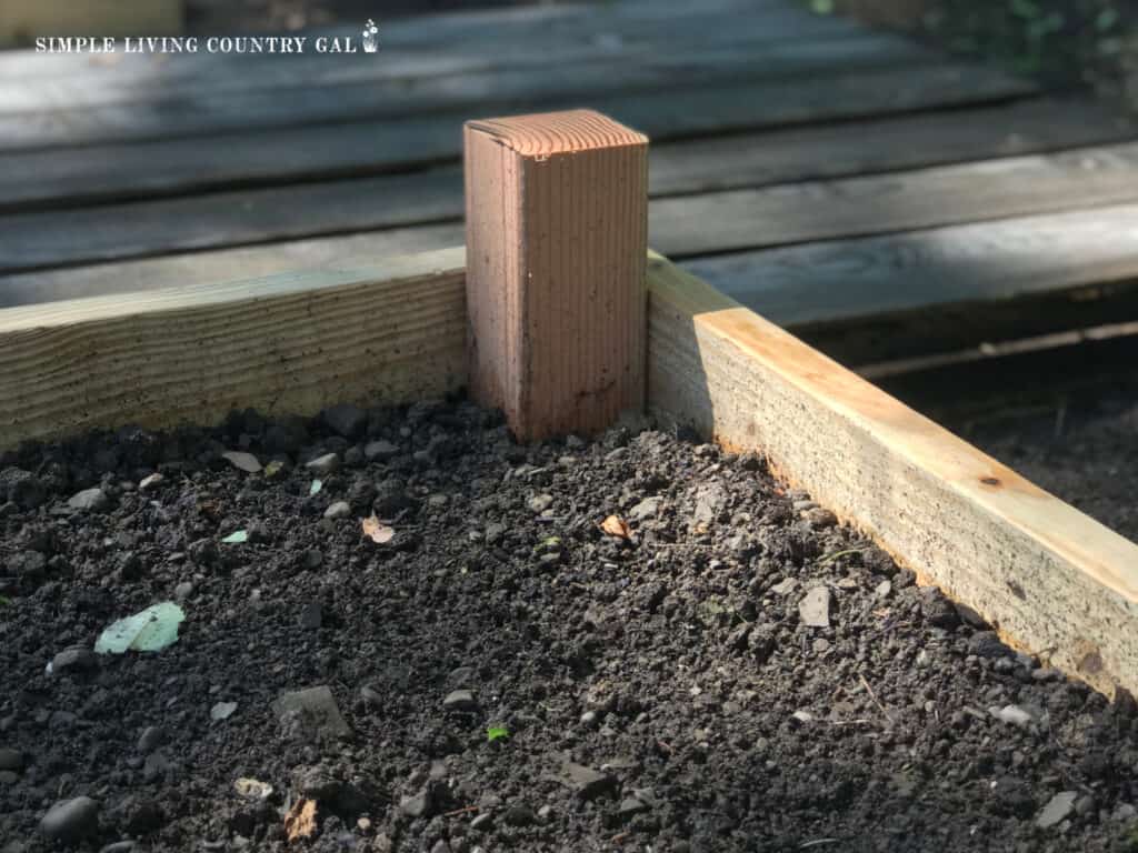 a corner support post in a raised garden bed