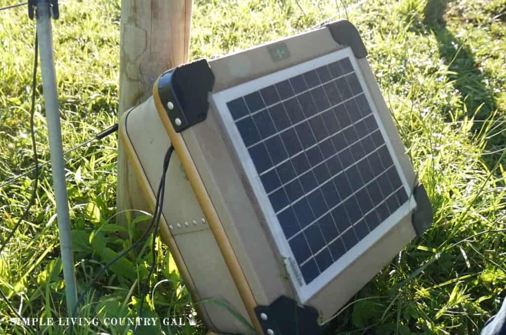 a solar power box at the base of a fence post