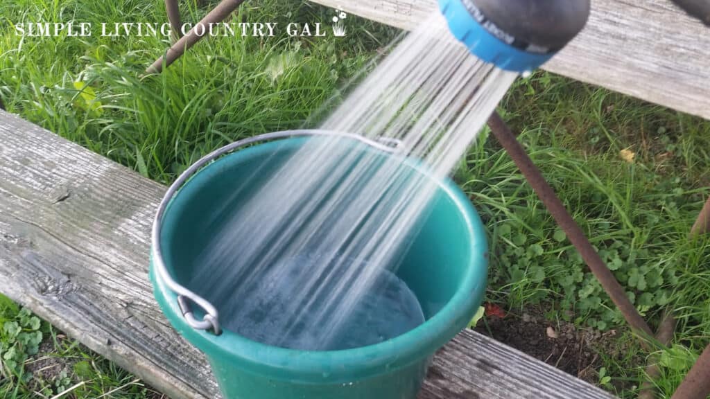 a shower of water going into a green bucket