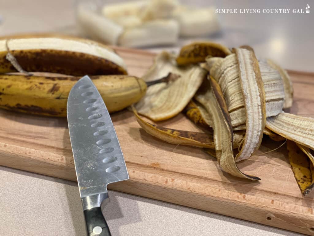 bananas on a cutting board with a knife