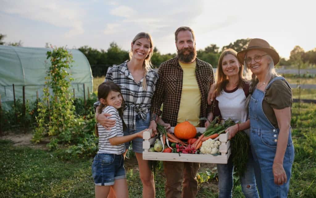 family posing in front of a community vegetable garden