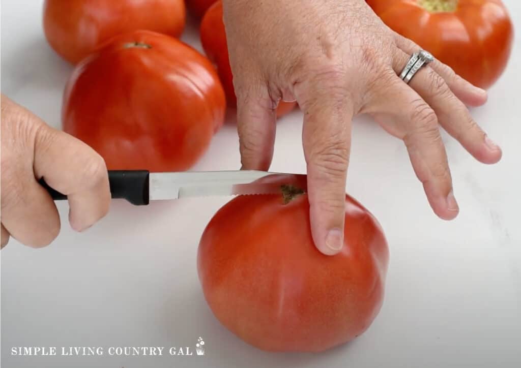 hands cutting a tomato 