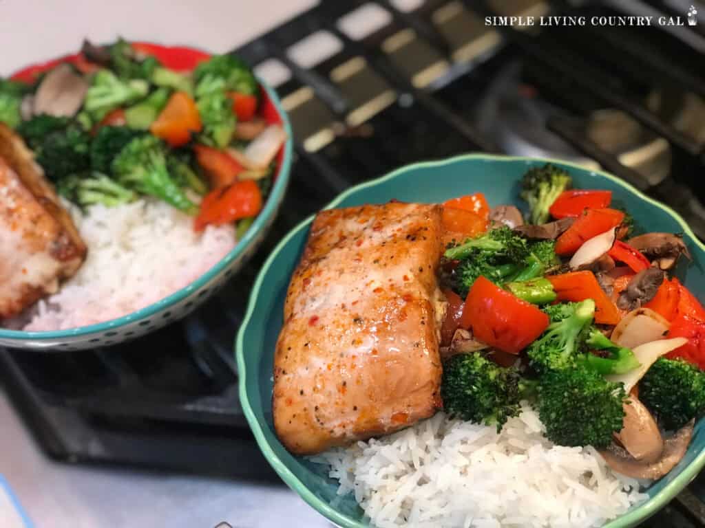 a salmon dish with rice and fresh veggies