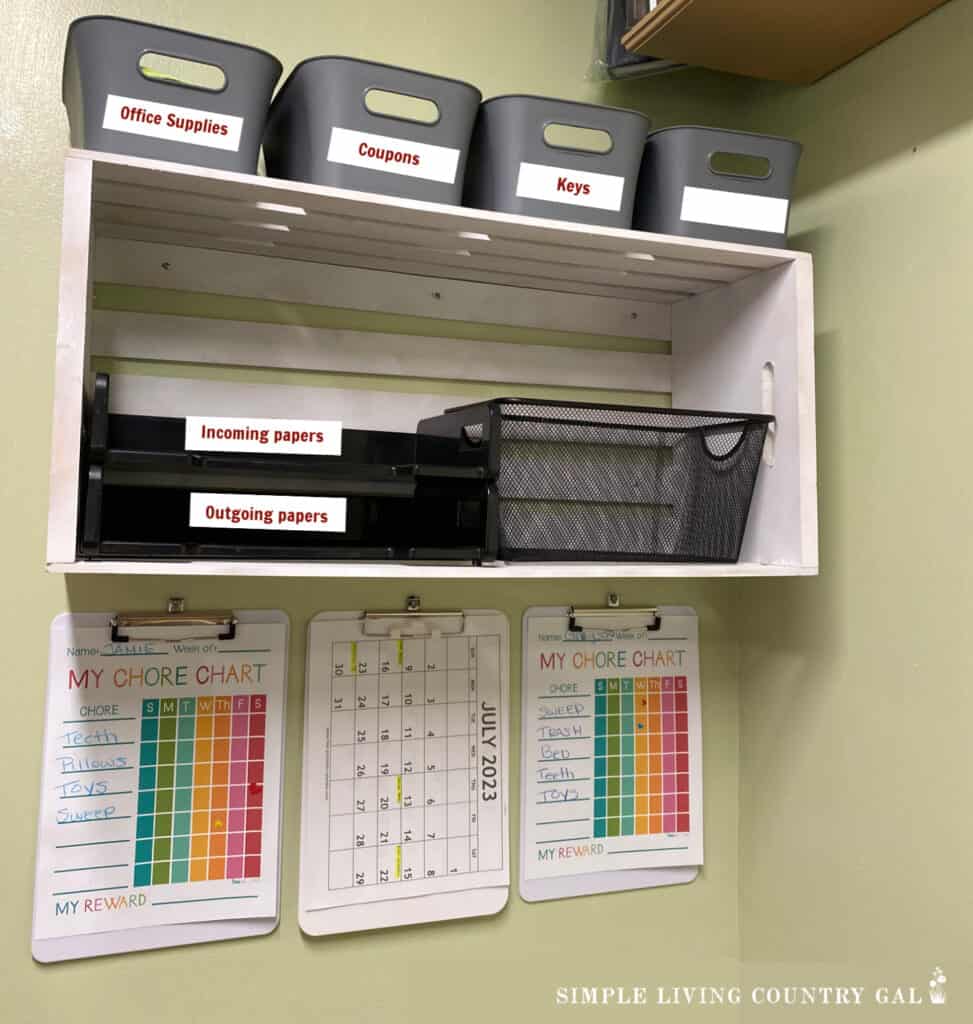 a shelf with baskets and hanging clipboards with chore charts and calendar