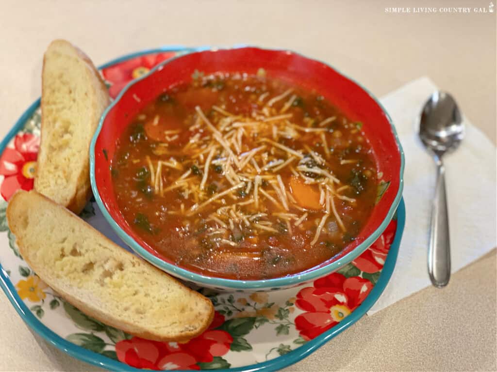 a dish of soup next to garlic toast on a plate