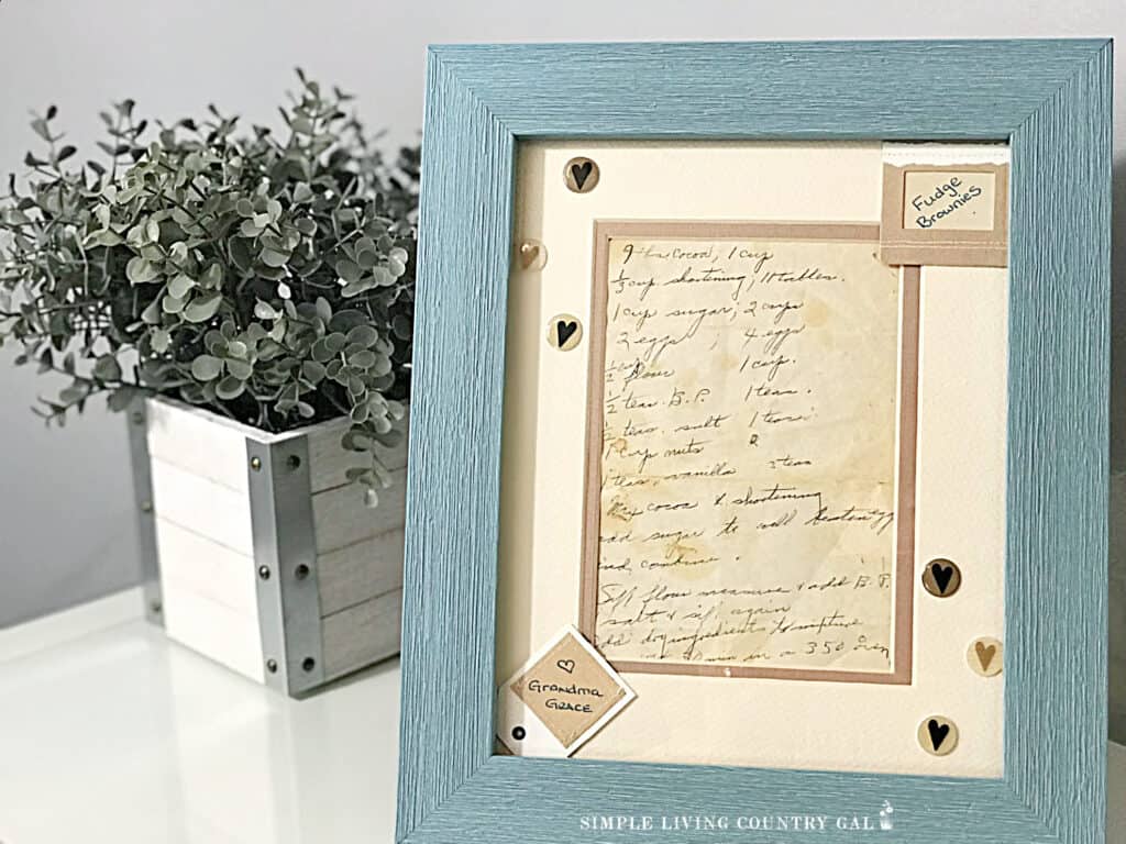 a family recipe that has been framed next to a plant 