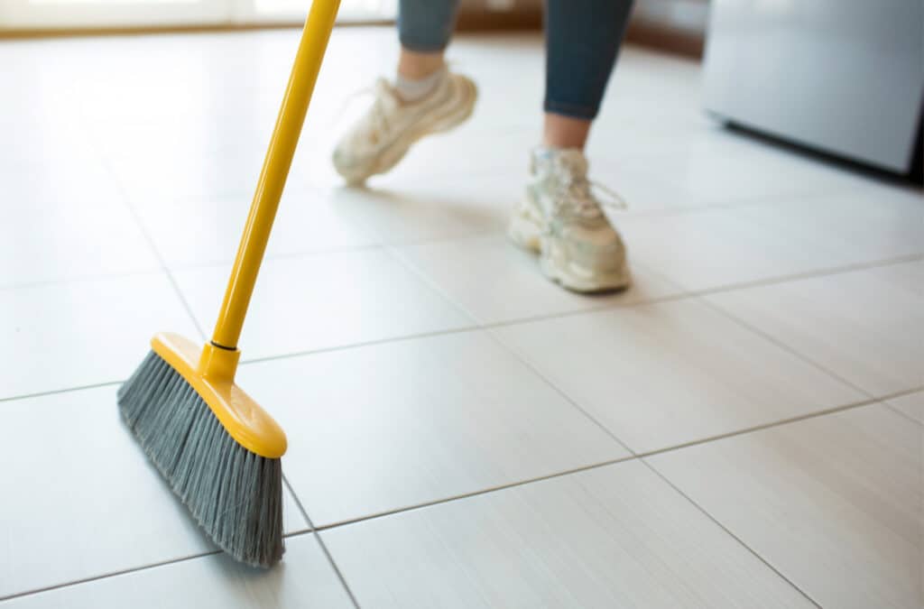 a woman sweeping a floor with a broom