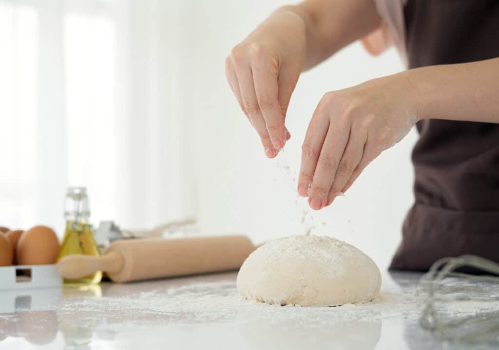 woman making bread dough in a kitchen