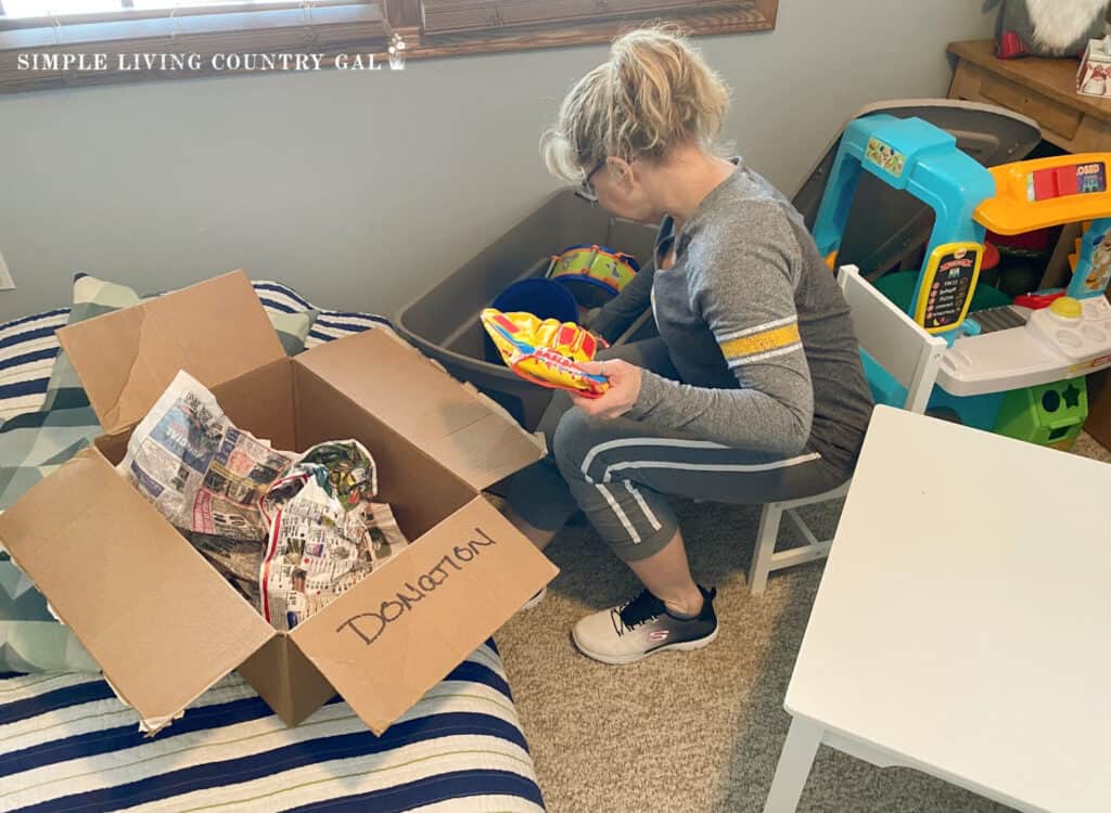 woman sorting through toys in a kids room copy