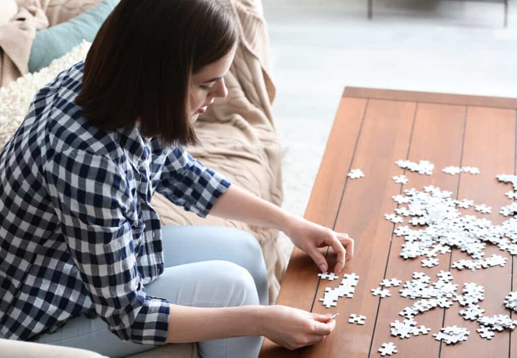 a woman doing jigsaw puzzle at home