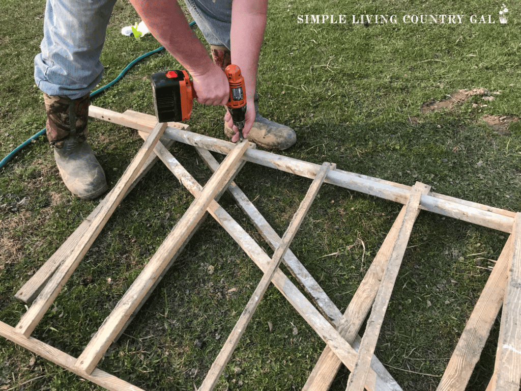 man screwing a board onto a chicken roost ladder